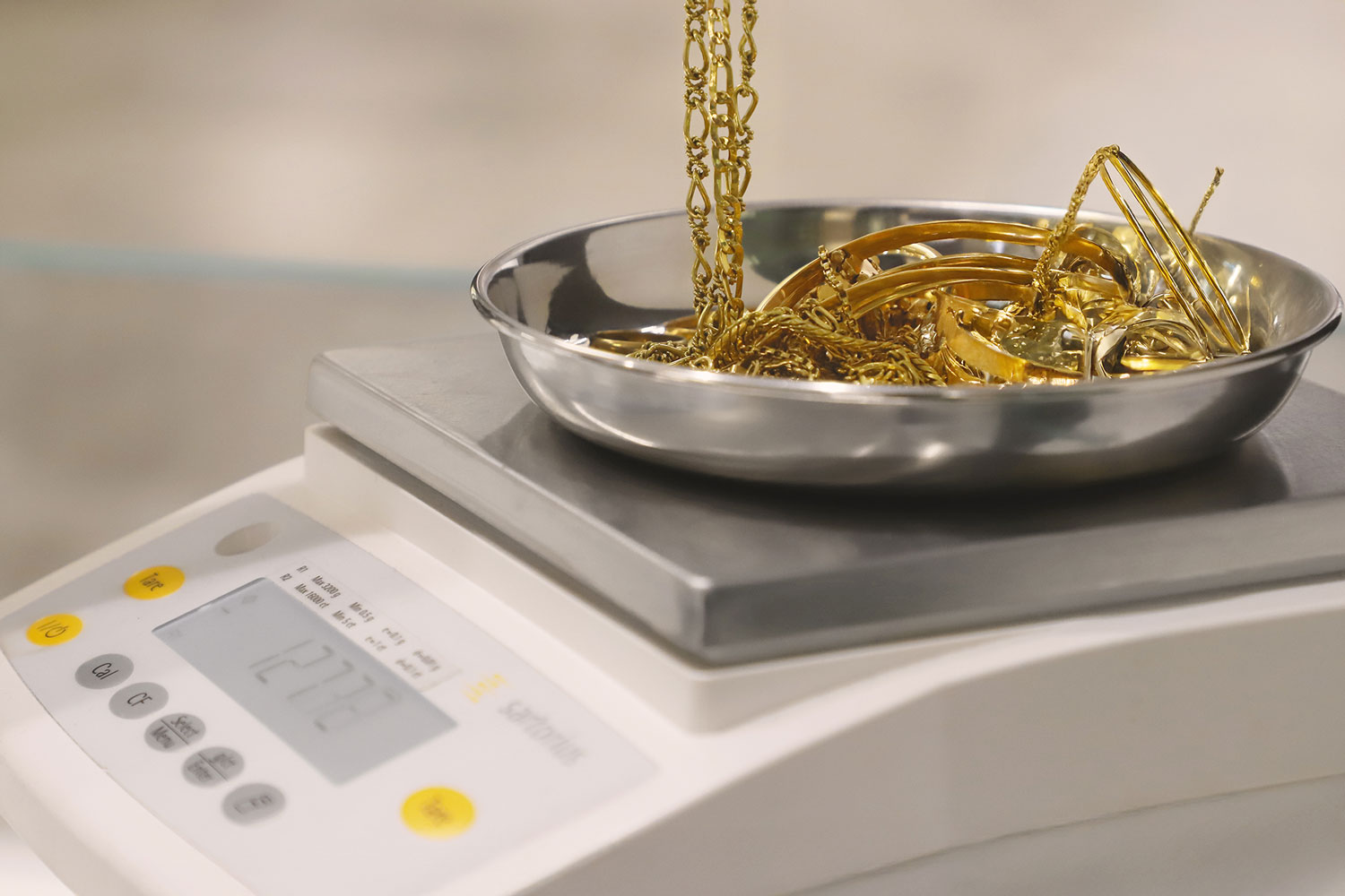 Pesatura di gioielli in oro con una bilancia professionale al fine della loro valutazione e permuta